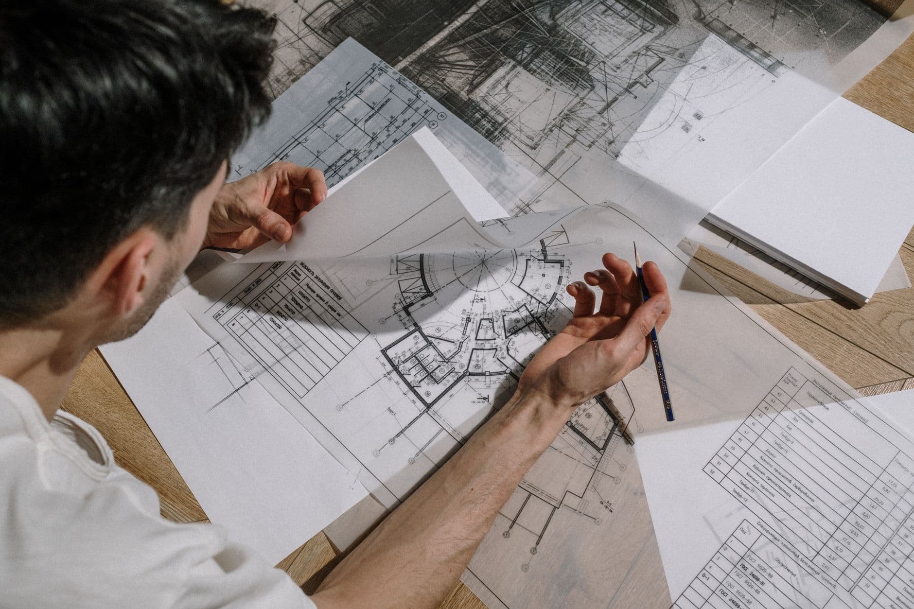 Engineer reviewing blueprints alongside financial documents at a desk