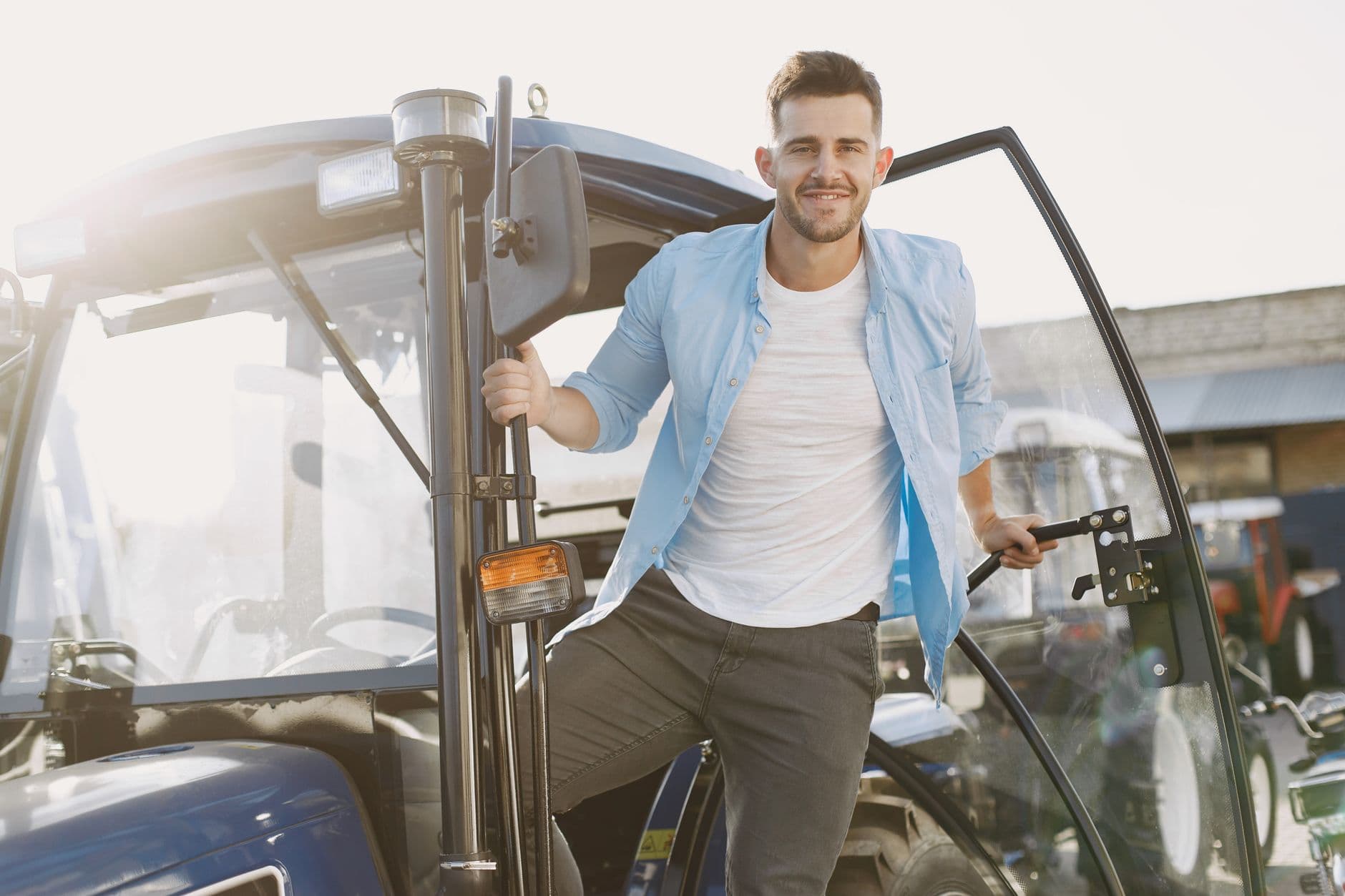 Farmer checking a smartphone app while sitting in a tractor cab