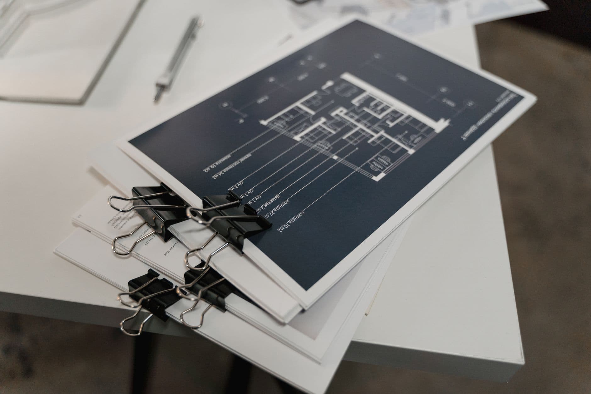Blueprints and tax documents laid out on an office desk