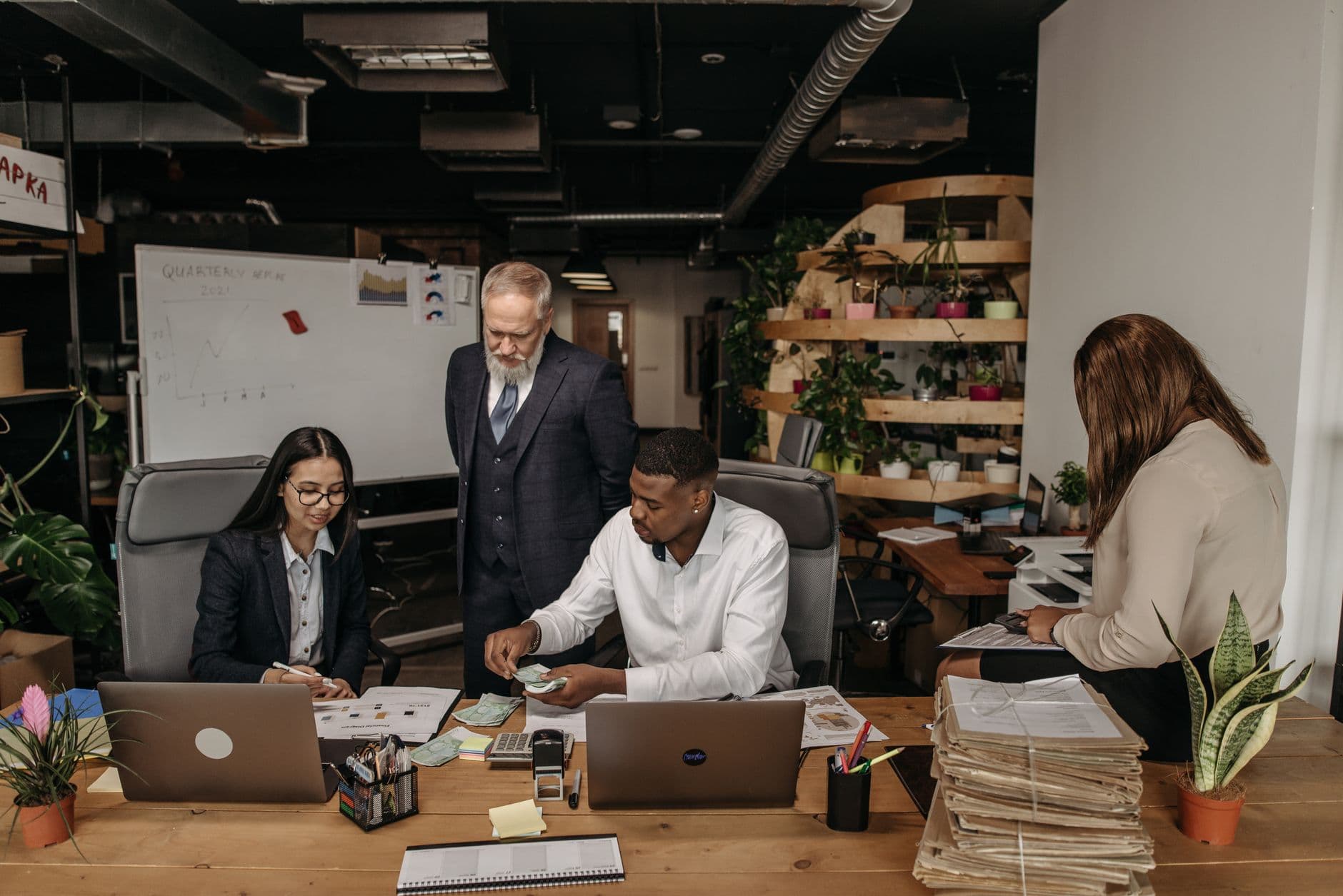 Three accounting professionals reviewing financial documents together at a desk